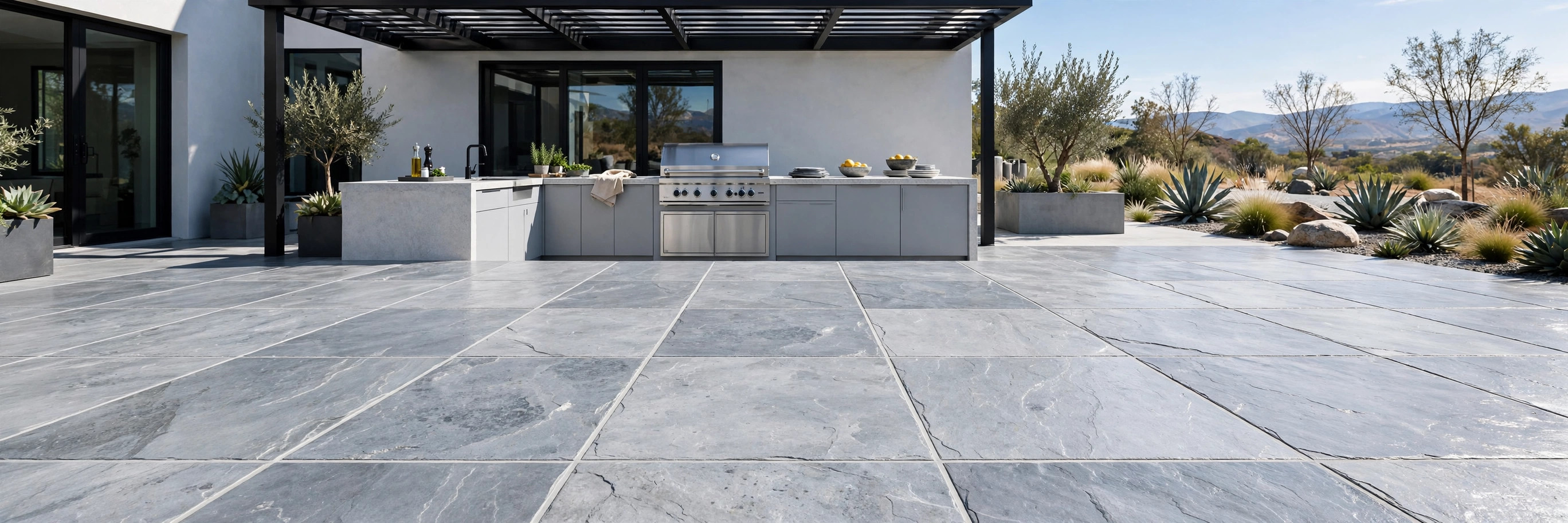 Large slate tile stamped concrete patio by an outdoor kitchen